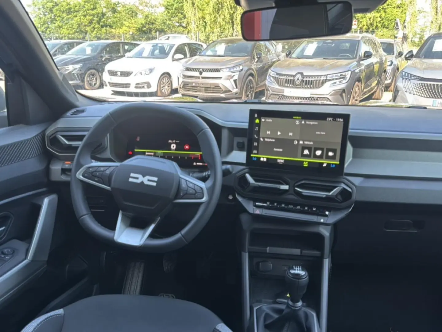 Vue intérieure avant du Dacia Bigster gris schiste, montrant le volant multifonction, l'écran tactile et la boîte manuelle.
