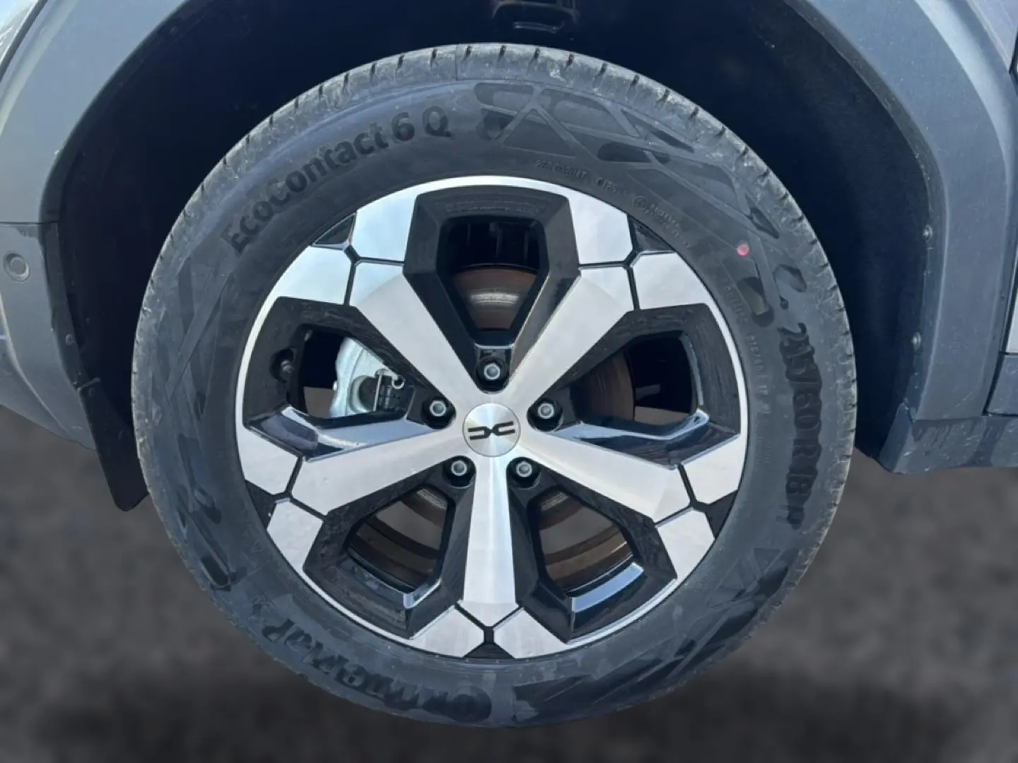 Gros plan sur la jante alu noire et argentée du Dacia Bigster gris schiste, mettant en valeur le design moderne du pneu EcoContact 6 Q.