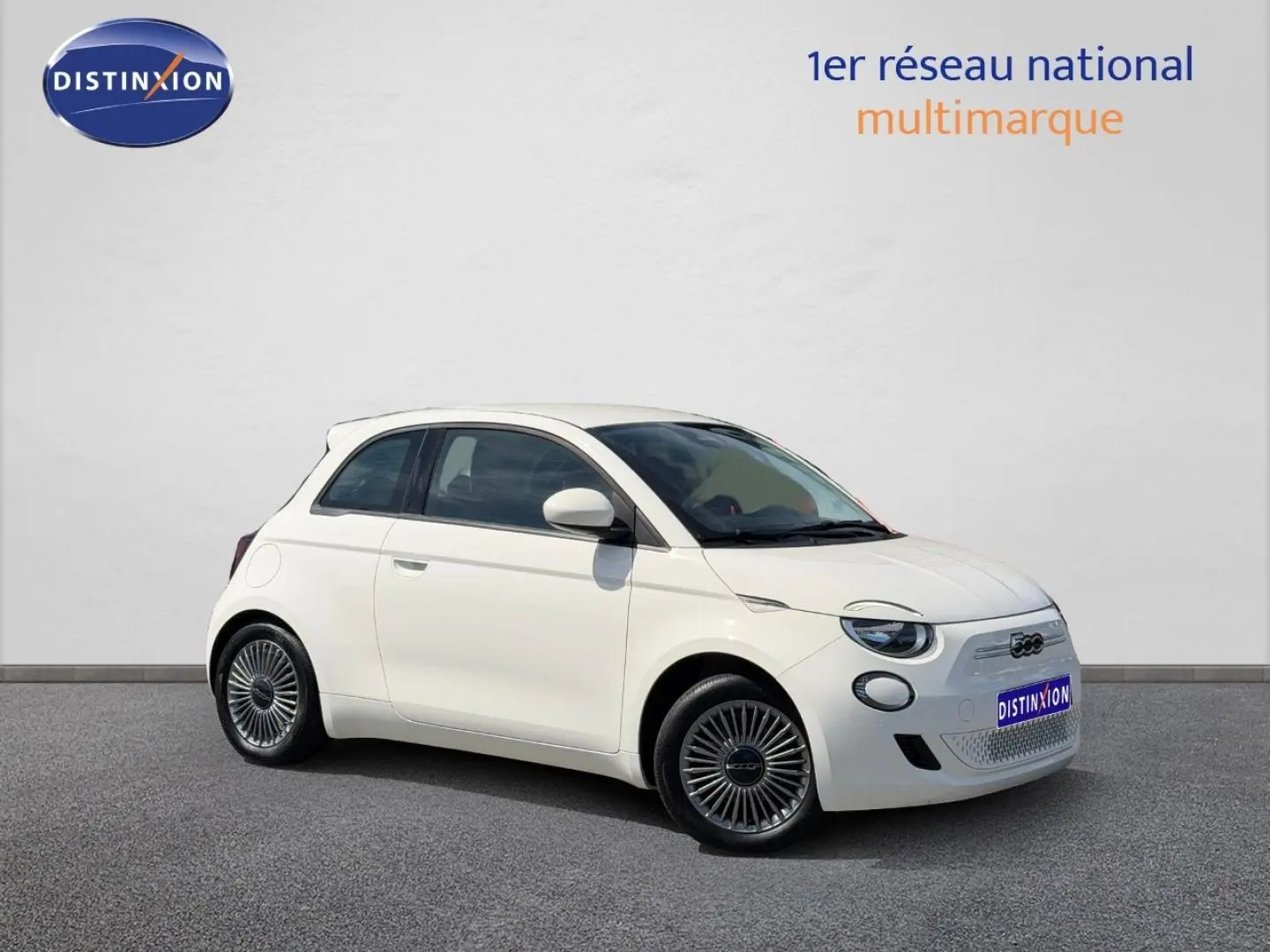 Fiat 500 e 118ch blanc vue 3/4 avant droit, avec jantes spécifiques et boucliers couleur carrosserie.