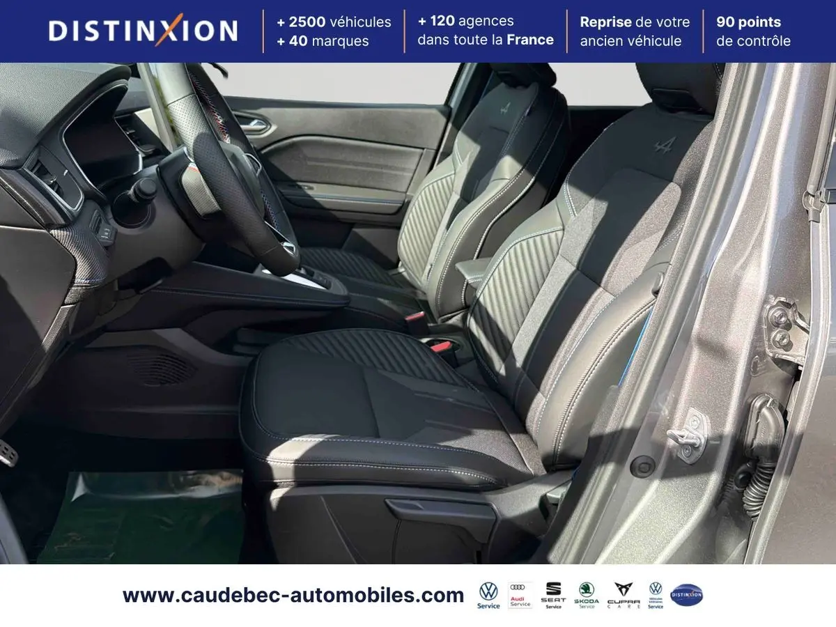 Vue intérieure côté gauche des sièges avant gris avec surpiqûres blanches du Renault Symbioz E-Tech 2026, porte ouverte.