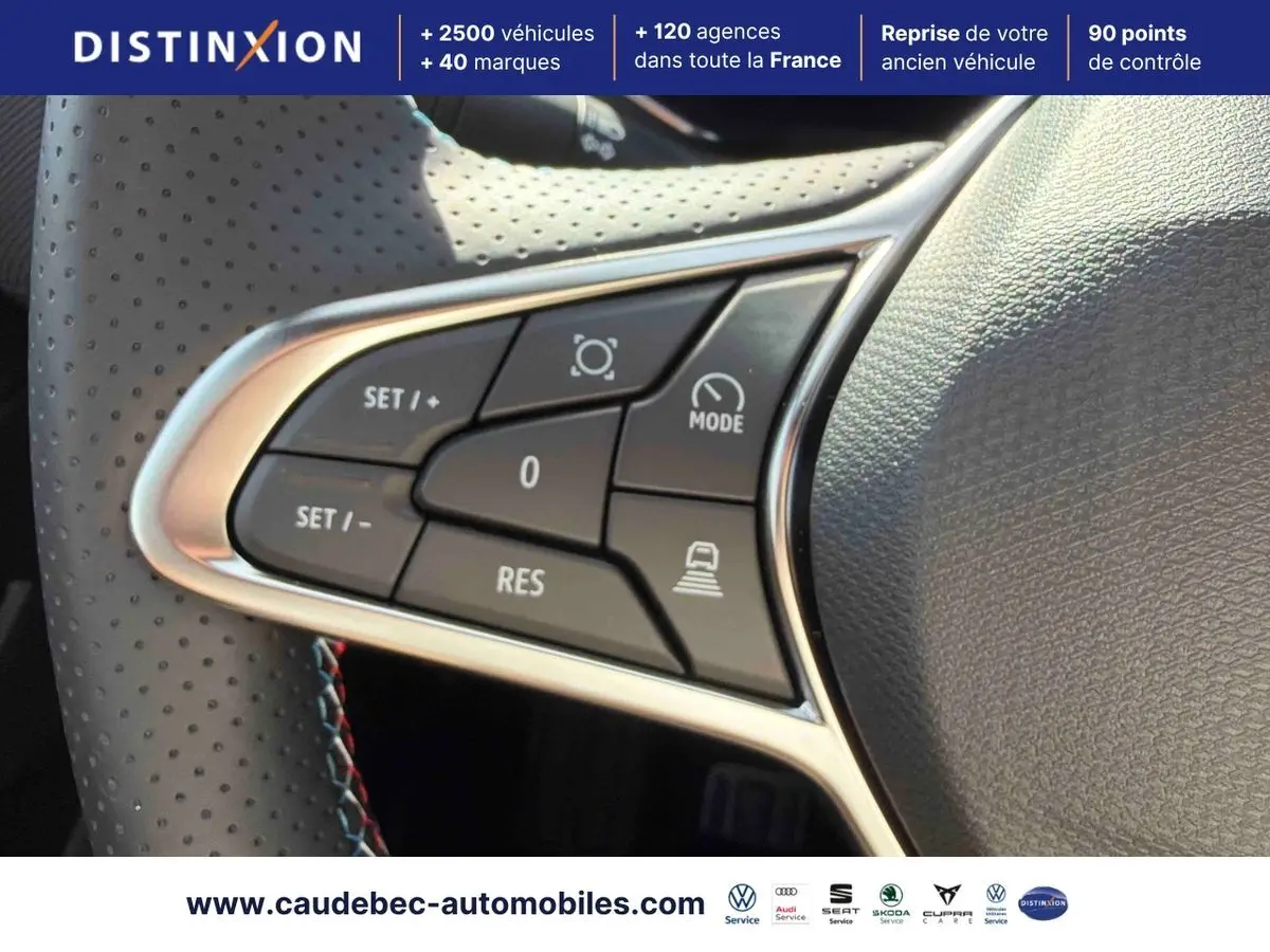Gros plan sur les commandes multifonctions du volant perforé noir du Renault Symbioz gris, avec contour chromé.