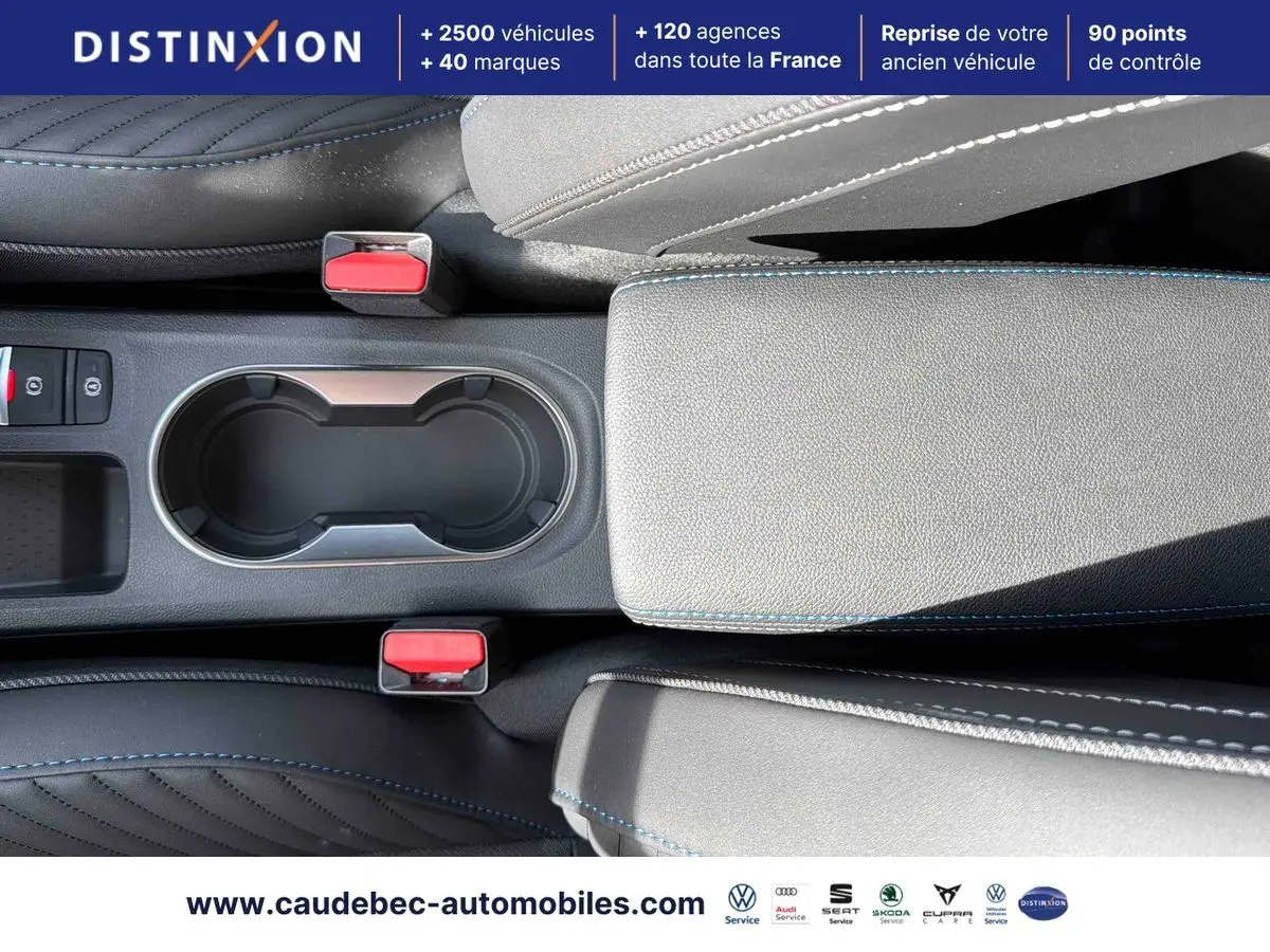 Vue plongeante sur la console centrale grise du Renault Symbioz 2026 avec porte-gobelets et coutures bleues contrastantes.