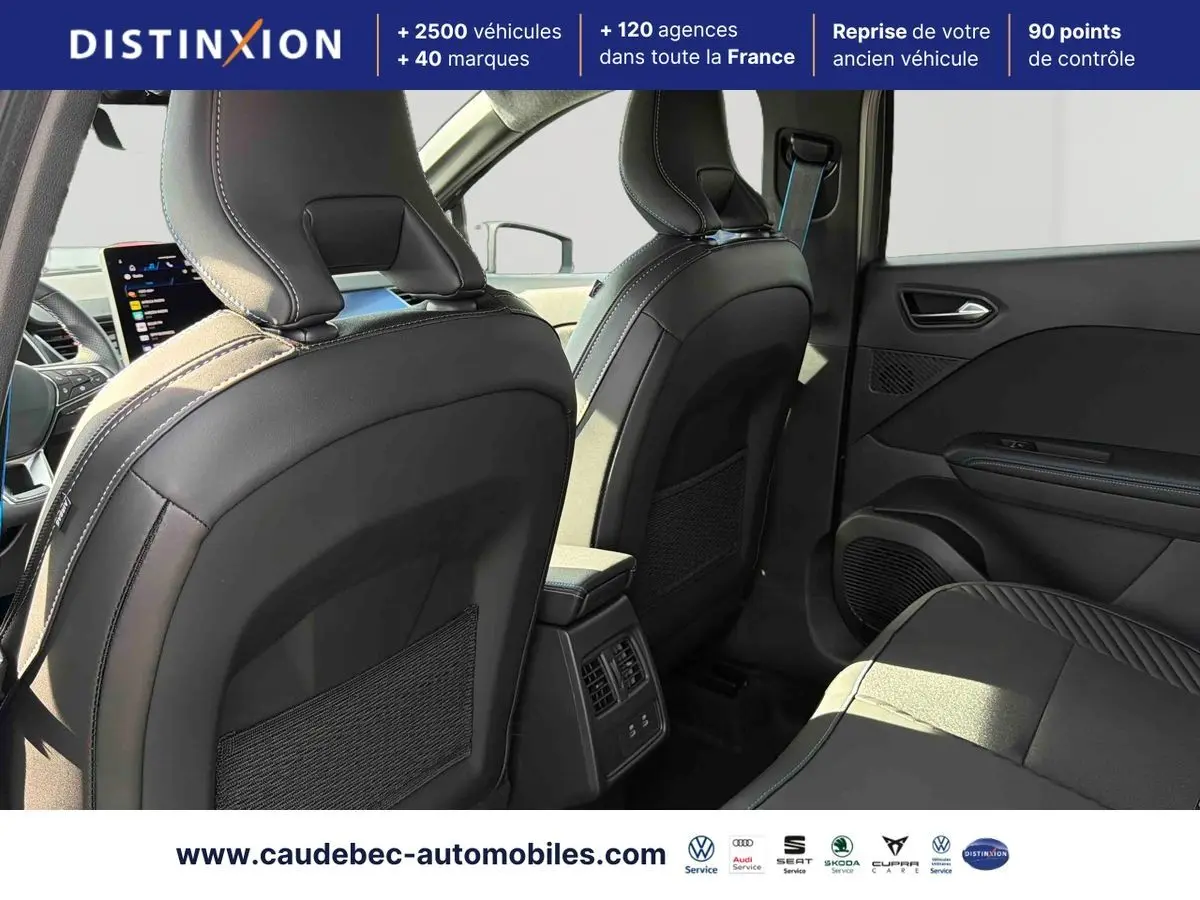 Vue intérieure arrière droite du Renault Symbioz 2026, sièges noirs en cuir avec surpiqûres contrastées et console centrale avec aérateurs.