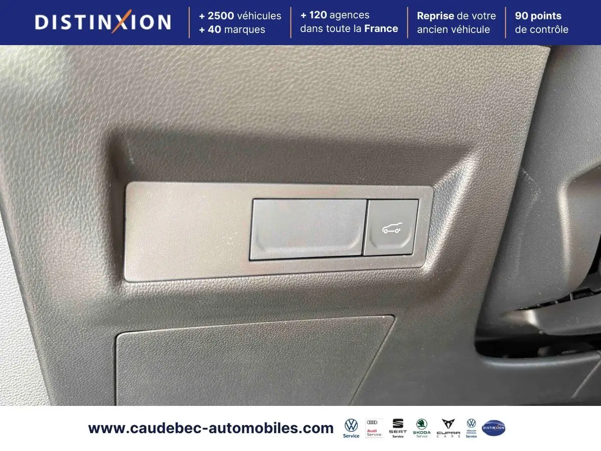 Détail du bouton d'ouverture du hayon sur la planche de bord grise de la Renault Symbioz E-Tech hybride 2026.