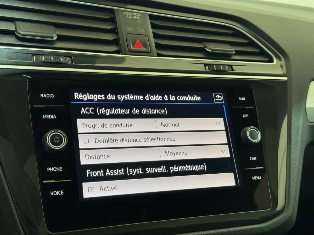Écran tactile central du Volkswagen Tiguan 2020 affichant les réglages d'aide à la conduite, intérieur noir.