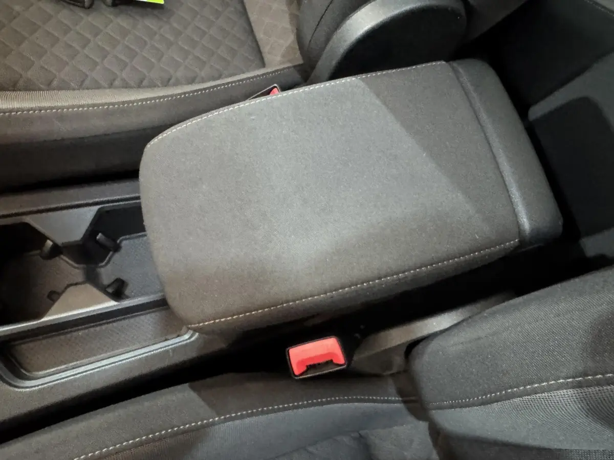 Vue rapprochée de l'accoudoir central noir et des sièges avant en tissu gris du Volkswagen Tiguan 2020 Confortline.