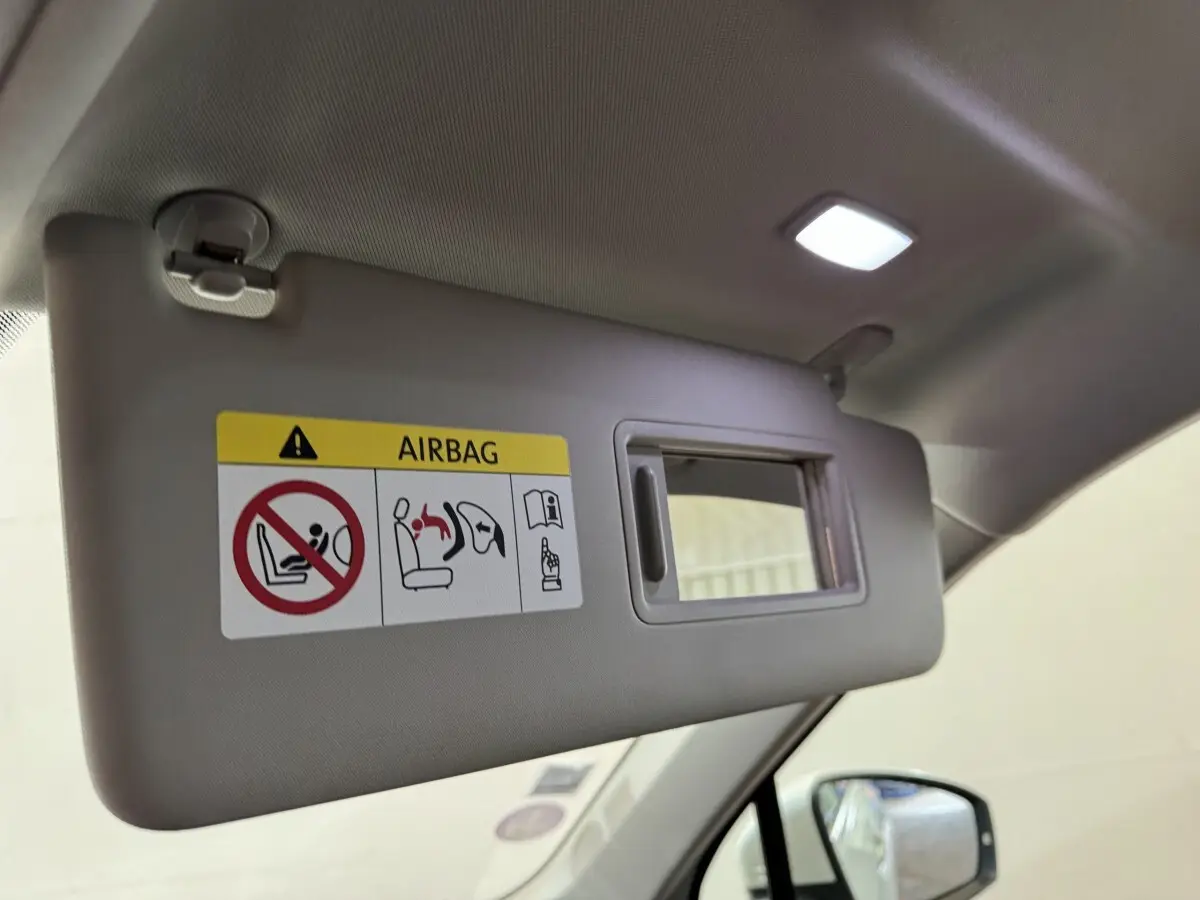 Détail du pare-soleil côté conducteur avec miroir et avertissement airbag dans un Volkswagen Tiguan blanc 2020.