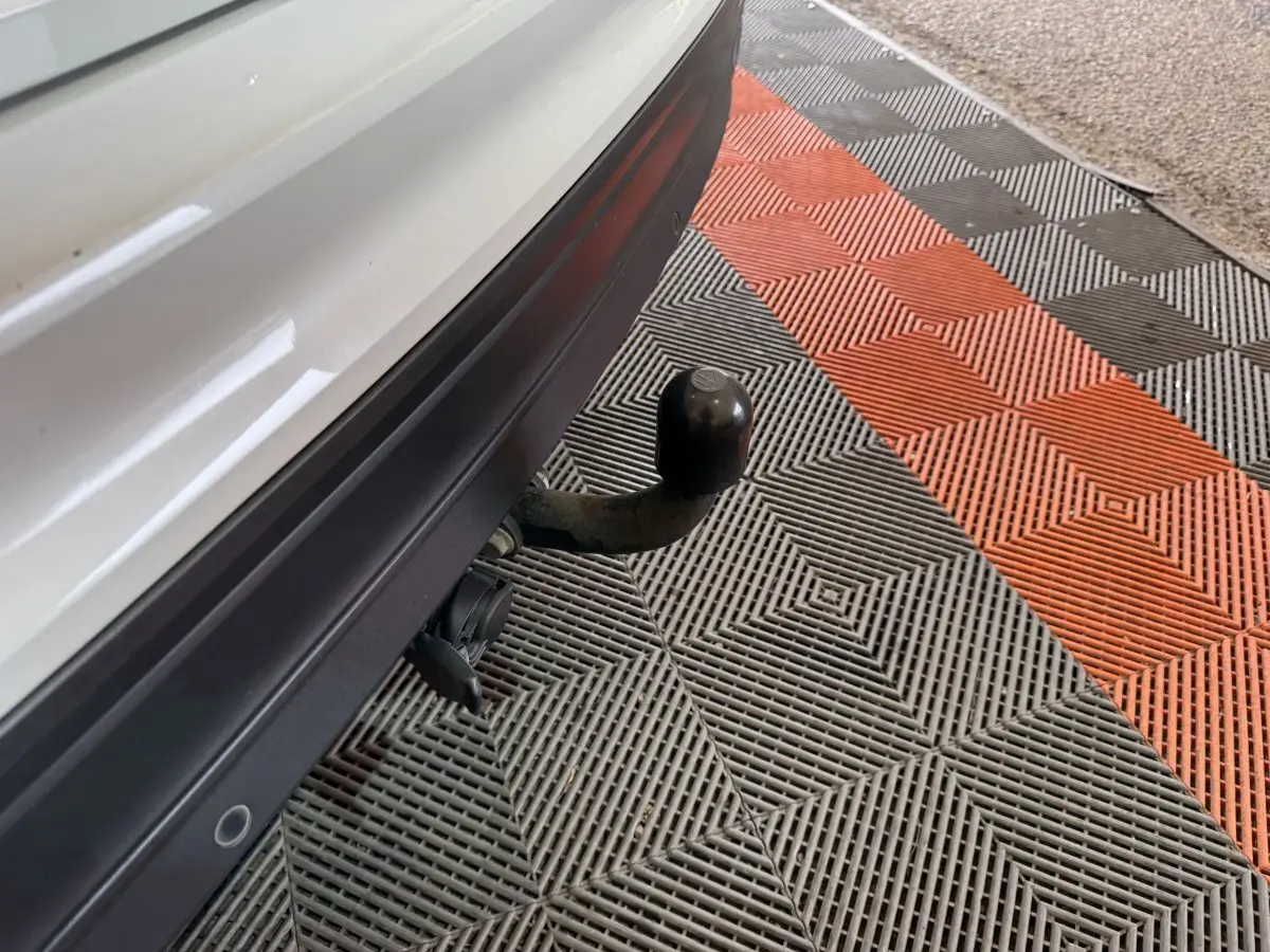 Gros plan sur l'attelage de remorque noir sous le pare-chocs arrière blanc du Volkswagen Tiguan 2020.