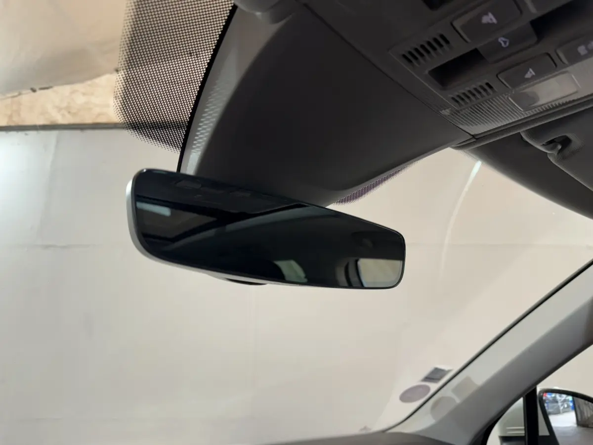 Rétroviseur intérieur noir du Volkswagen Tiguan blanc 2020, vue rapprochée depuis l'habitacle côté conducteur.