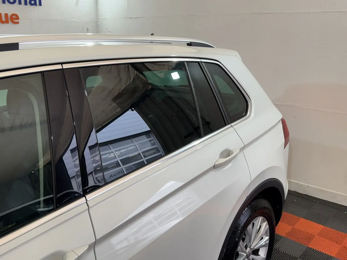 Vue côté droit arrière du Volkswagen Tiguan blanc 2020 avec vitres teintées et jantes alliage.
