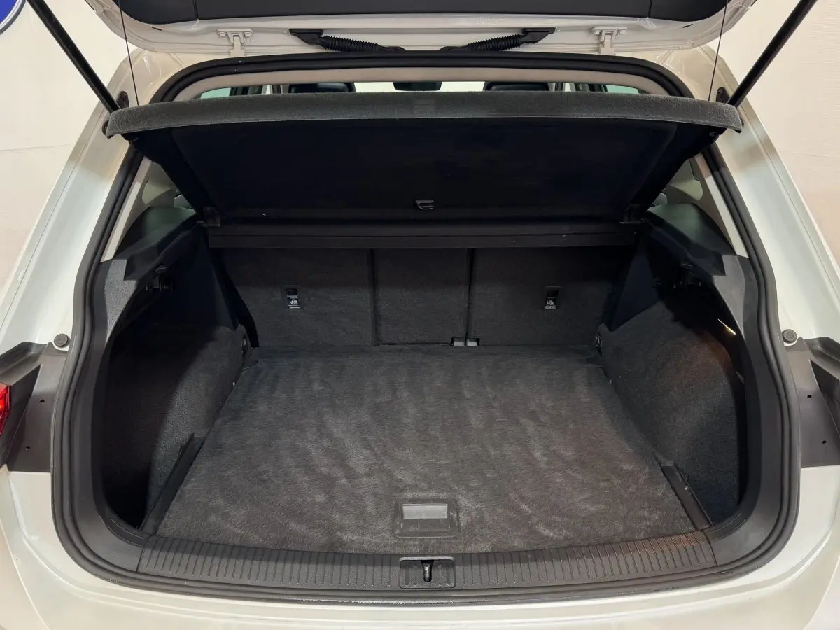 Coffre ouvert d'un Volkswagen Tiguan blanc 2020 vu de l'arrière, montrant un espace de chargement spacieux et propre.