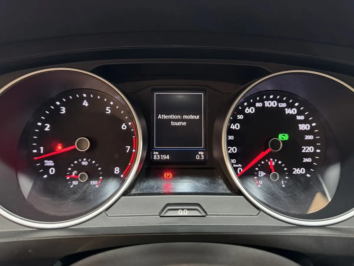 Tableau de bord du Volkswagen Tiguan 2020 avec compte-tours, vitesse, et écran central affichant "Attention : moteur tourne"