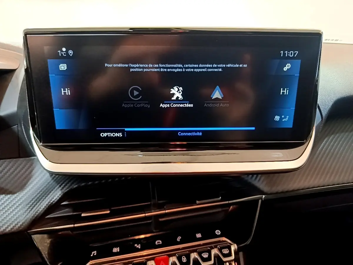 Écran tactile central de la Peugeot 208 jaune 2023 affichant les options Apple CarPlay et Android Auto.