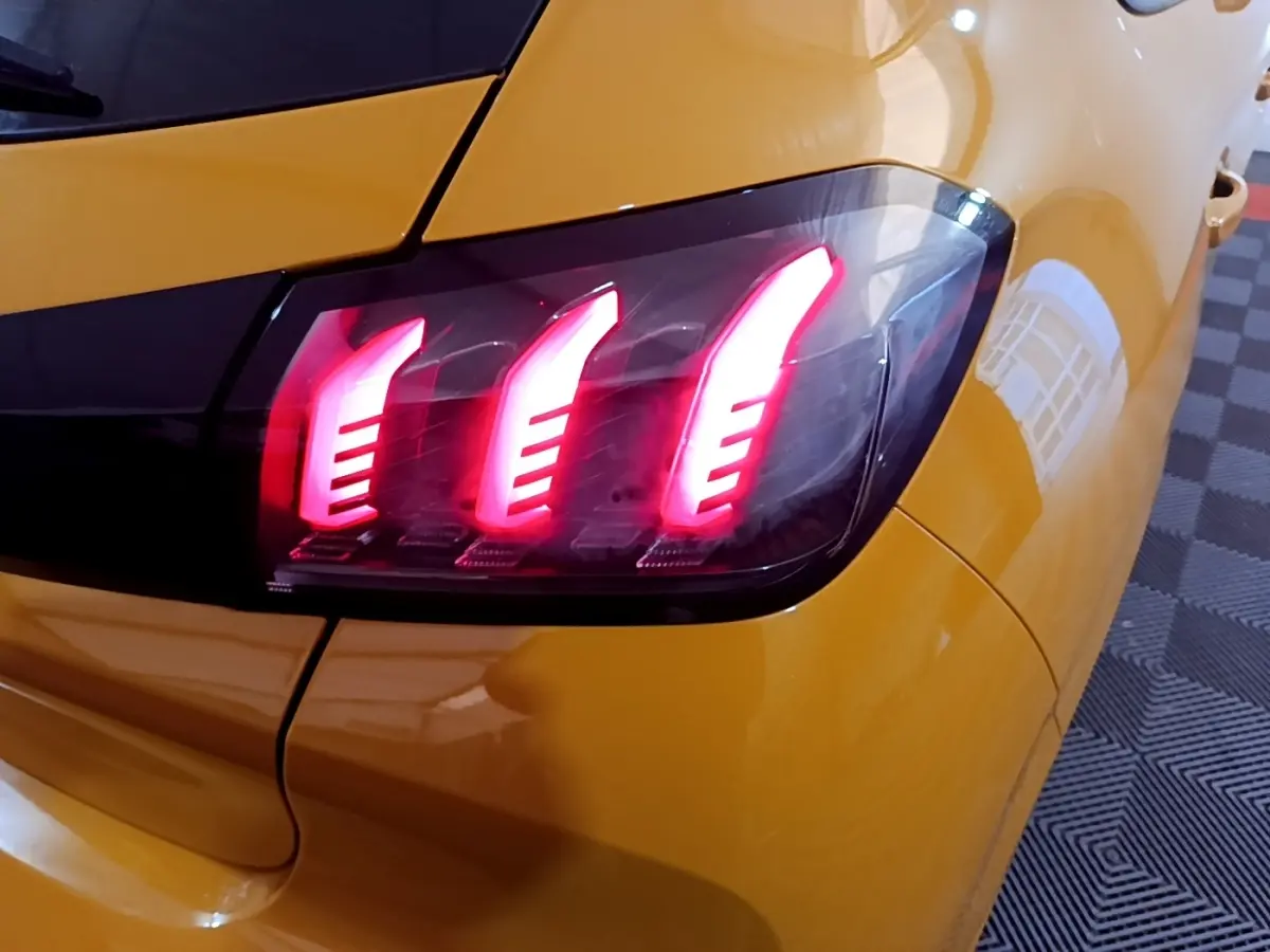 Gros plan sur le feu arrière droit allumé d'une Peugeot 208 jaune PureTech 100 S&S Allure Pack 2023.