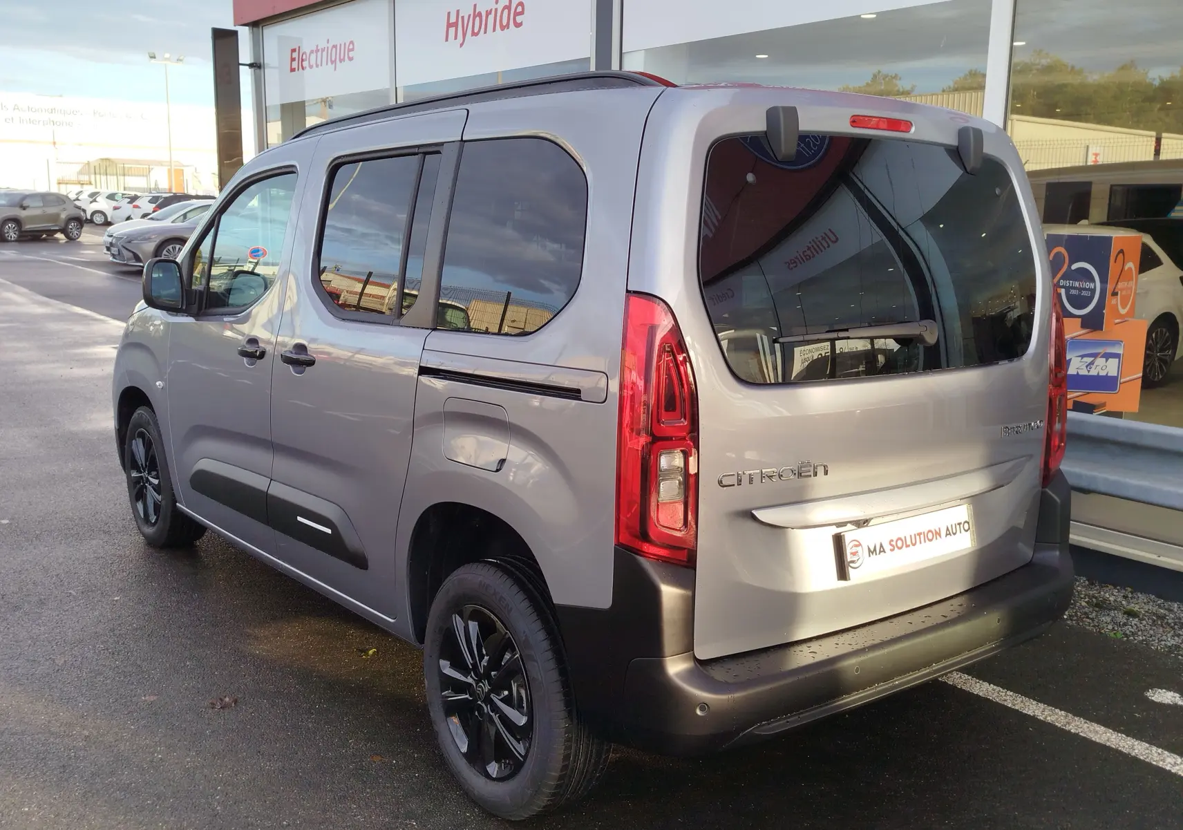 Vue 3/4 arrière droite du Citroën Berlingo gris acier 2025 avec vitres teintées et jantes noires.