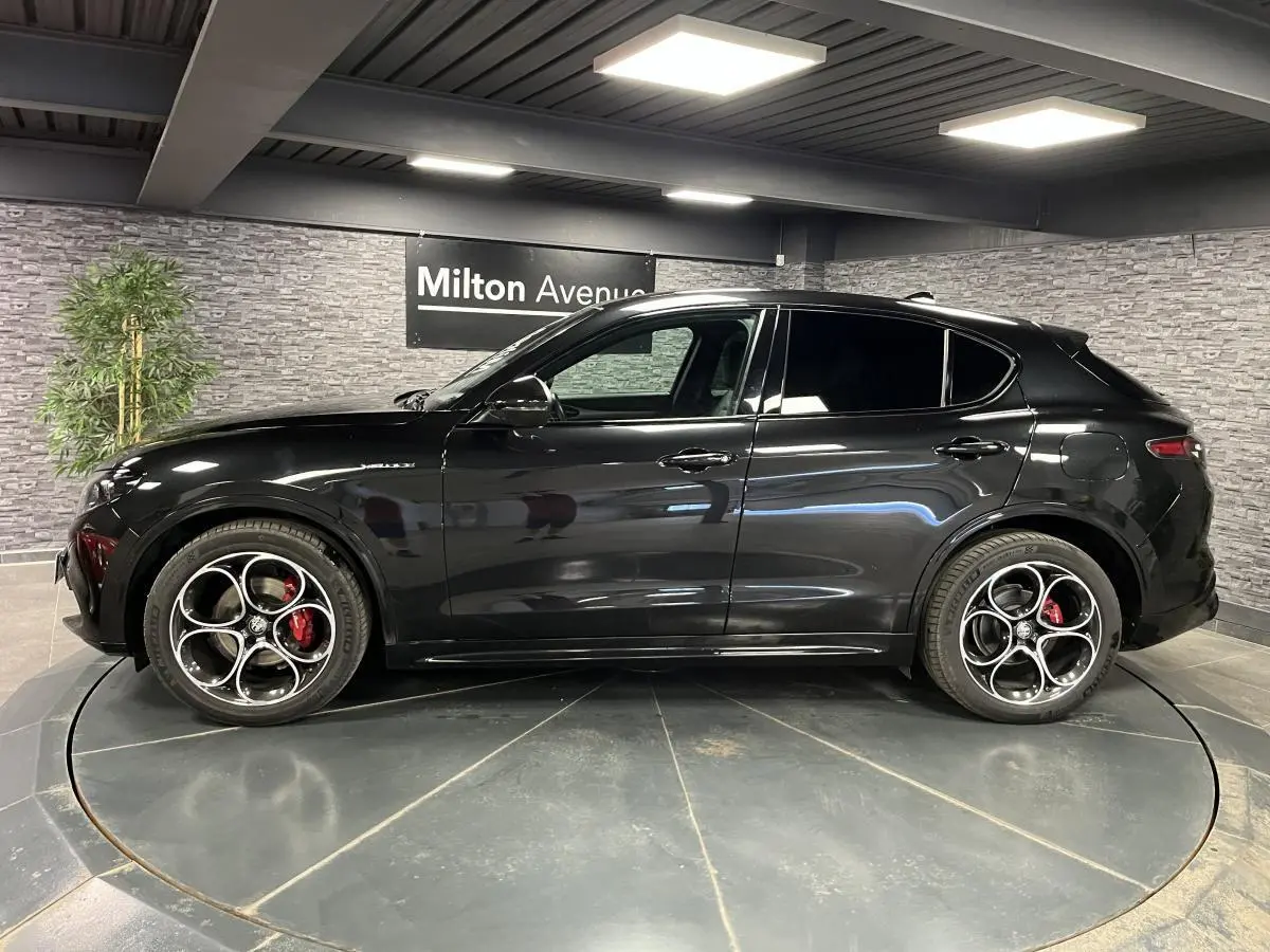 Vue latérale droite de l'Alfa Romeo Stelvio Veloce noire avec jantes 20 pouces et étriers de freins rouges Brembo.