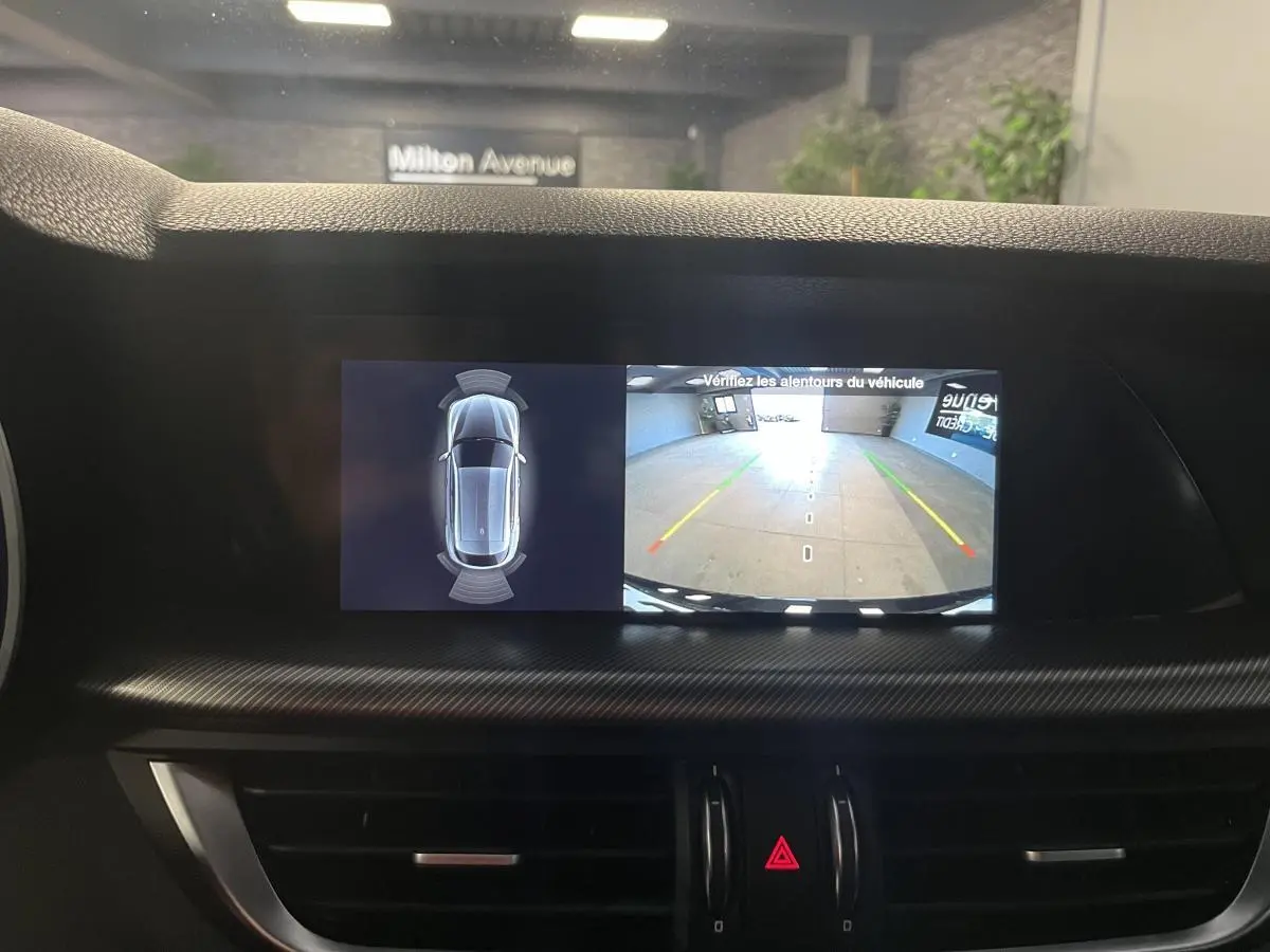 Écran central de l'Alfa Romeo Stelvio 2024 affichant la caméra de recul et l'aide au stationnement en intérieur.