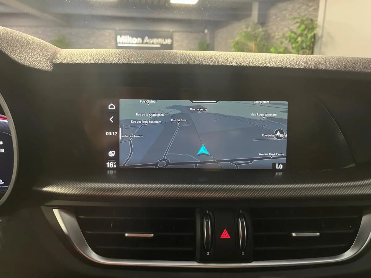 Vue intérieure centrée sur l'écran tactile de navigation du tableau de bord de l'Alfa Romeo Stelvio noir 2024.