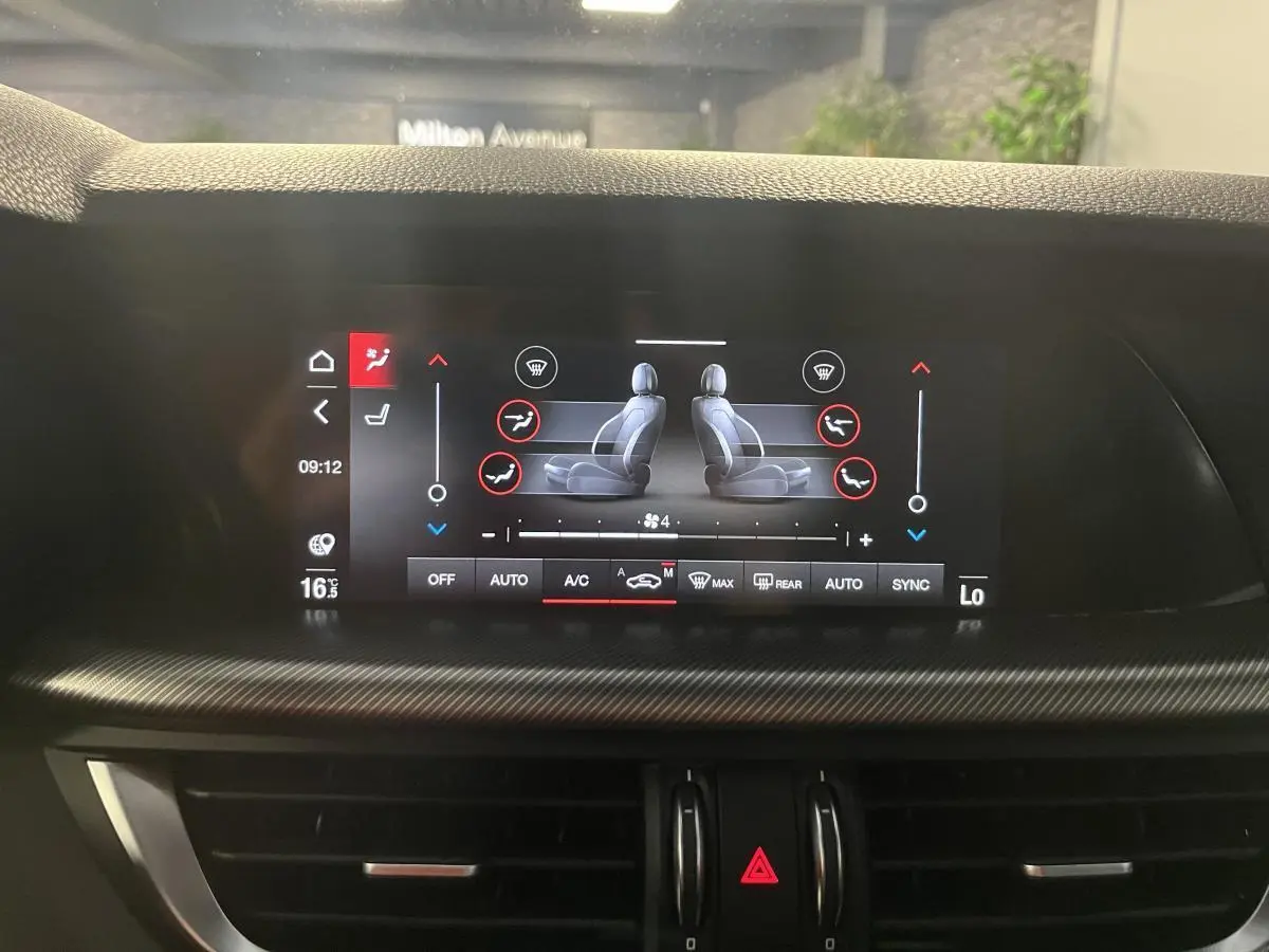 Écran tactile du système de climatisation affichant les réglages des sièges chauffants dans un Alfa Romeo Stelvio noir.