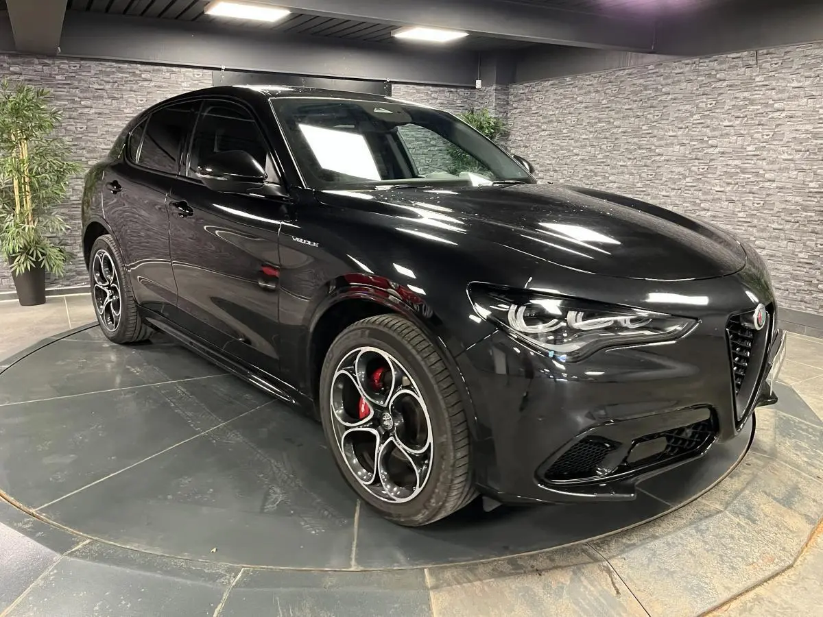 Alfa Romeo Stelvio Veloce noir, vue 3/4 avant droit, jantes alliage 20 pouces et étriers de freins rouges visibles.