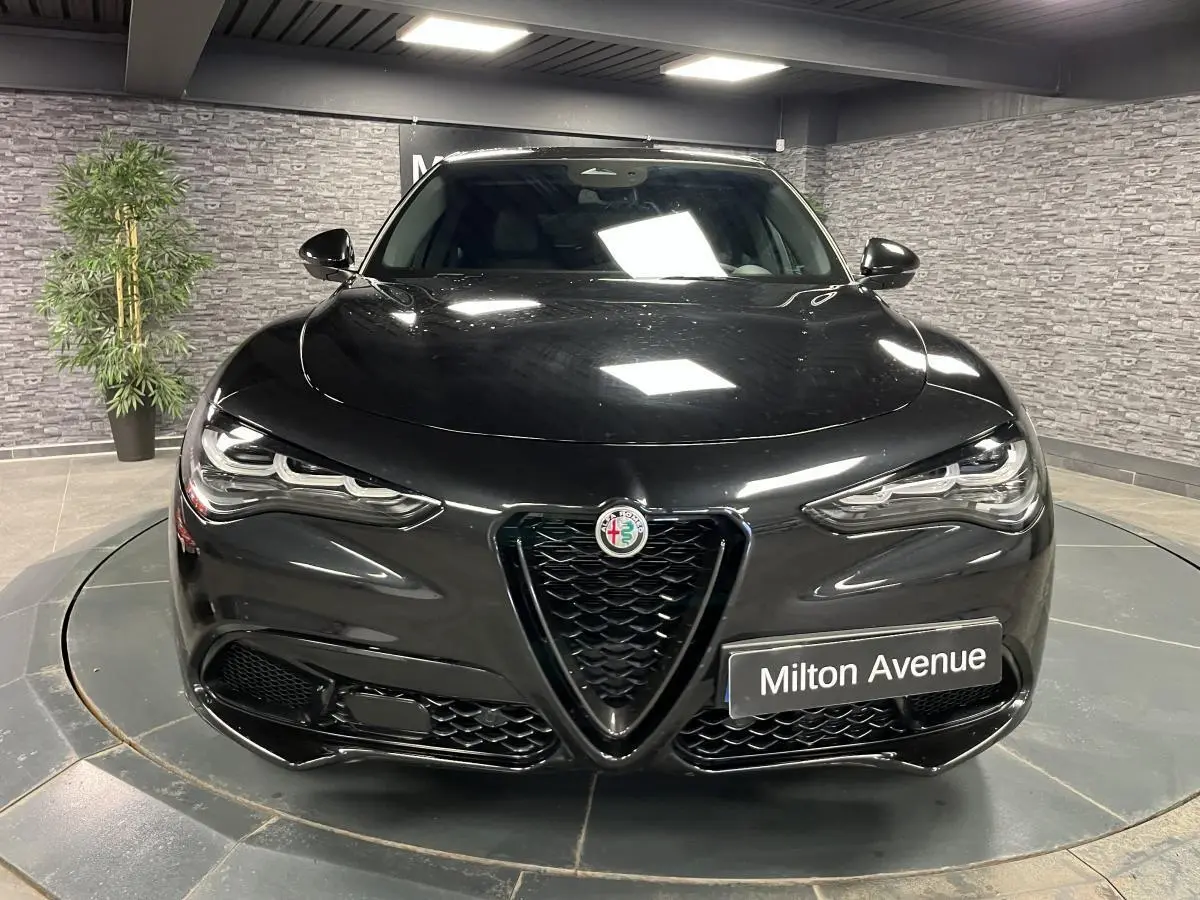 Vue avant d'un Alfa Romeo Stelvio 2.2 D Veloce noir Vulcano avec calandre en V et phares LED distinctifs.