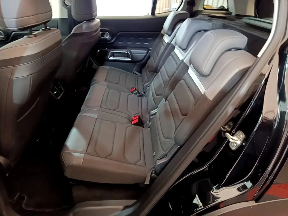Vue côté droit sur les sièges arrière noirs du Citroën C5 Aircross hybride rechargeable 2022 avec portes ouvertes.