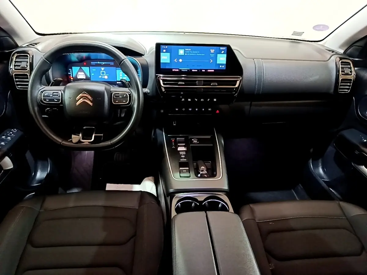 Intérieur noir du Citroën C5 Aircross hybride rechargeable vu de face, avec tableau de bord digital et écran tactile central.