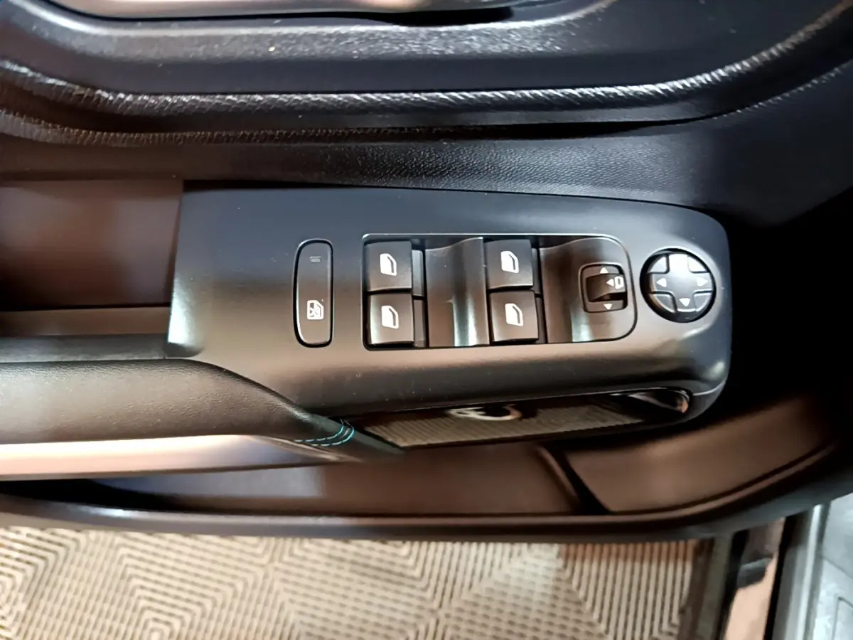 Gros plan sur les commandes de lève-vitres et réglage des rétroviseurs côté conducteur d’un Citroën C5 Aircross noir 2022.