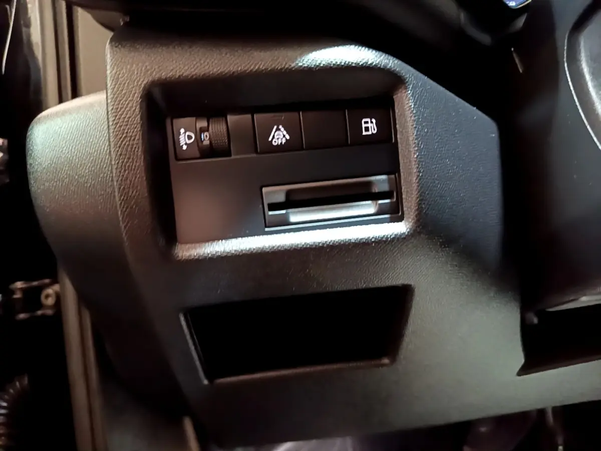 Détail intérieur côté gauche du tableau de bord noir du Citroën C5 Aircross hybride avec commandes d’éclairage et aide à la conduite.