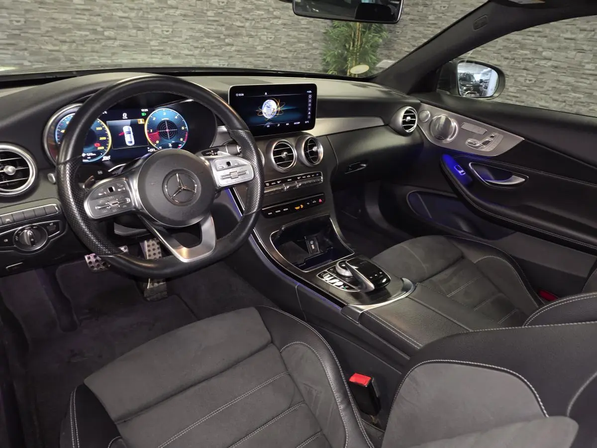 Vue intérieure côté conducteur de la Mercedes Classe C Coupé AMG Line 2019, avec combiné digital et ambiance noire élégante.