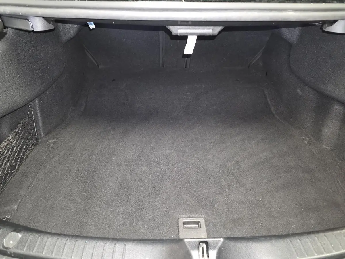 Coffre ouvert de la Mercedes Classe C Coupé gris, montrant un espace de rangement propre et vide.