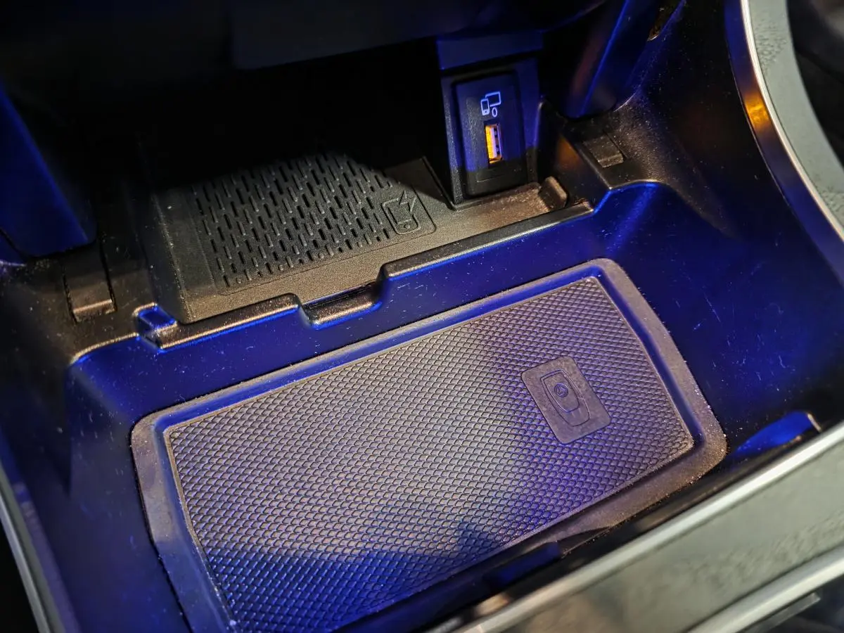 Gros plan sur le compartiment central avec recharge smartphone sans fil et prise USB dans la Mercedes Classe C Coupé gris.