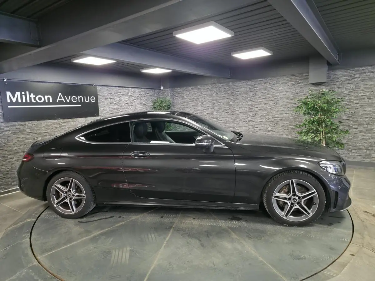 Mercedes Classe C Coupé gris métallisé vue de profil côté gauche avec jantes AMG 18 pouces à 5 branches doubles.