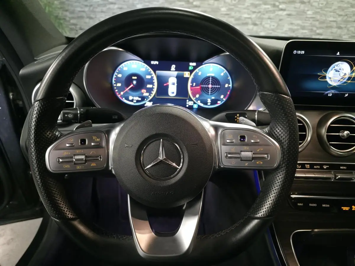 Vue rapprochée du volant cuir perforé et du combiné digital de la Mercedes Classe C Coupé gris 2019 AMG Line.