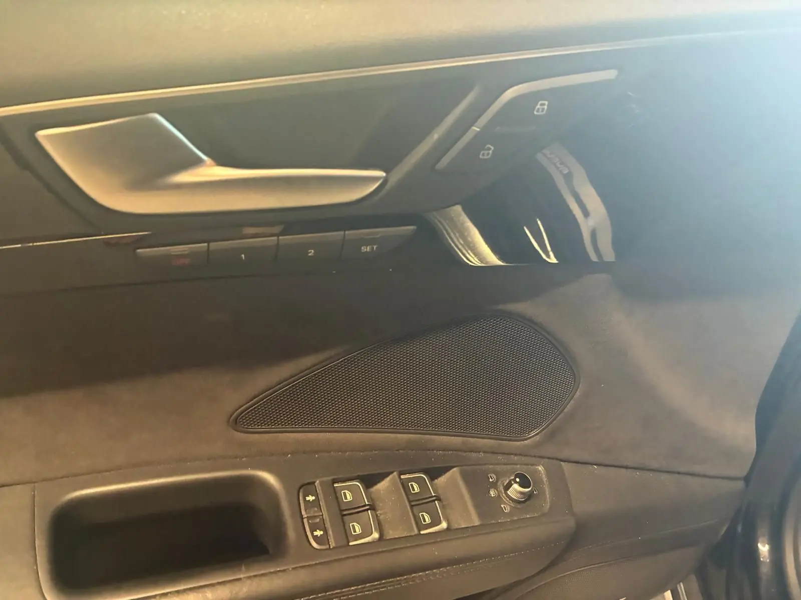 Détail de la porte côté conducteur de l'Audi A8 noire 2016, avec commandes de vitres et réglages des miroirs.