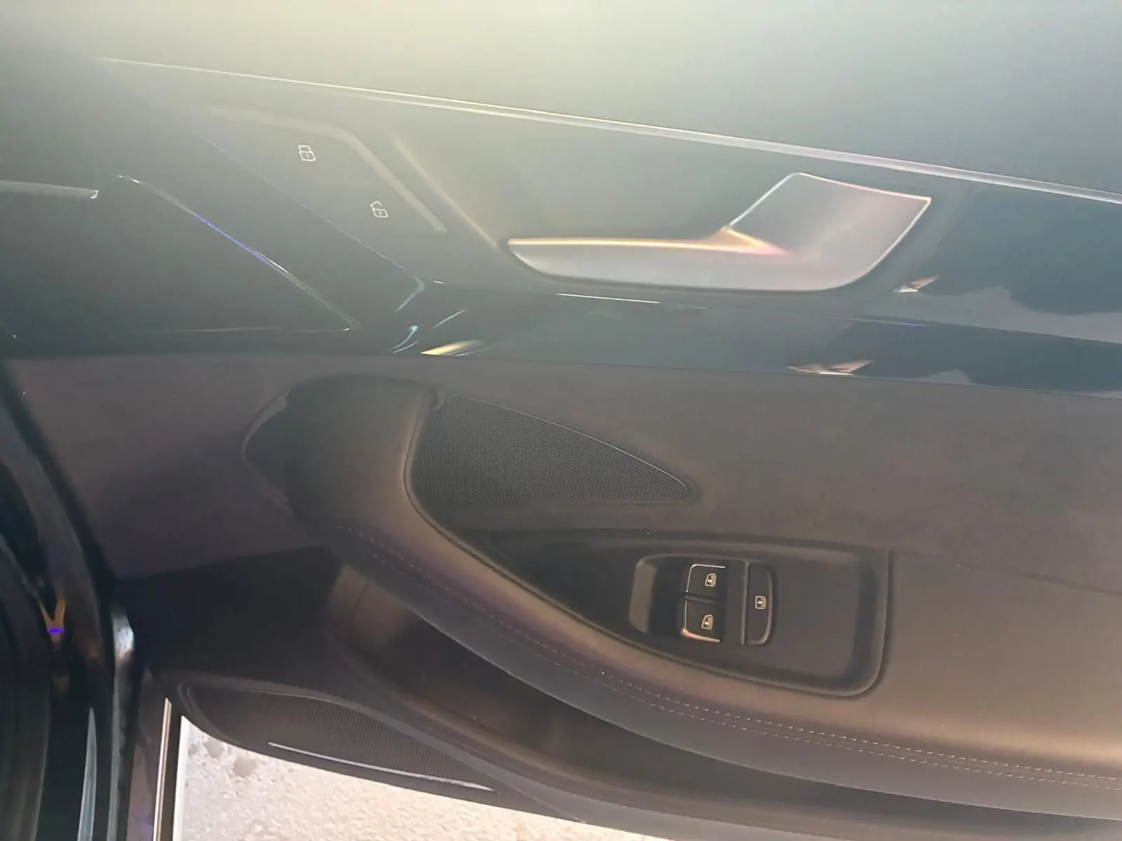 Détail de la porte intérieure côté conducteur de l’Audi A8 noire 2016 avec commandes de verrouillage et poignée argentée.