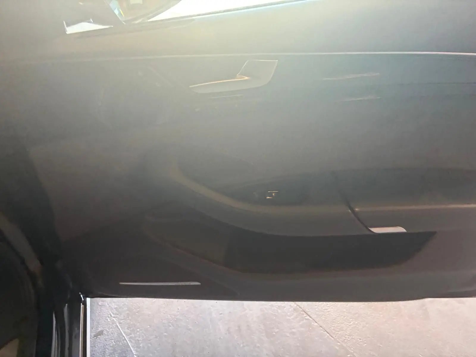 Vue intérieure de la porte côté conducteur de l'Audi A8 noire 2016, mettant en valeur les commandes et le design épuré.