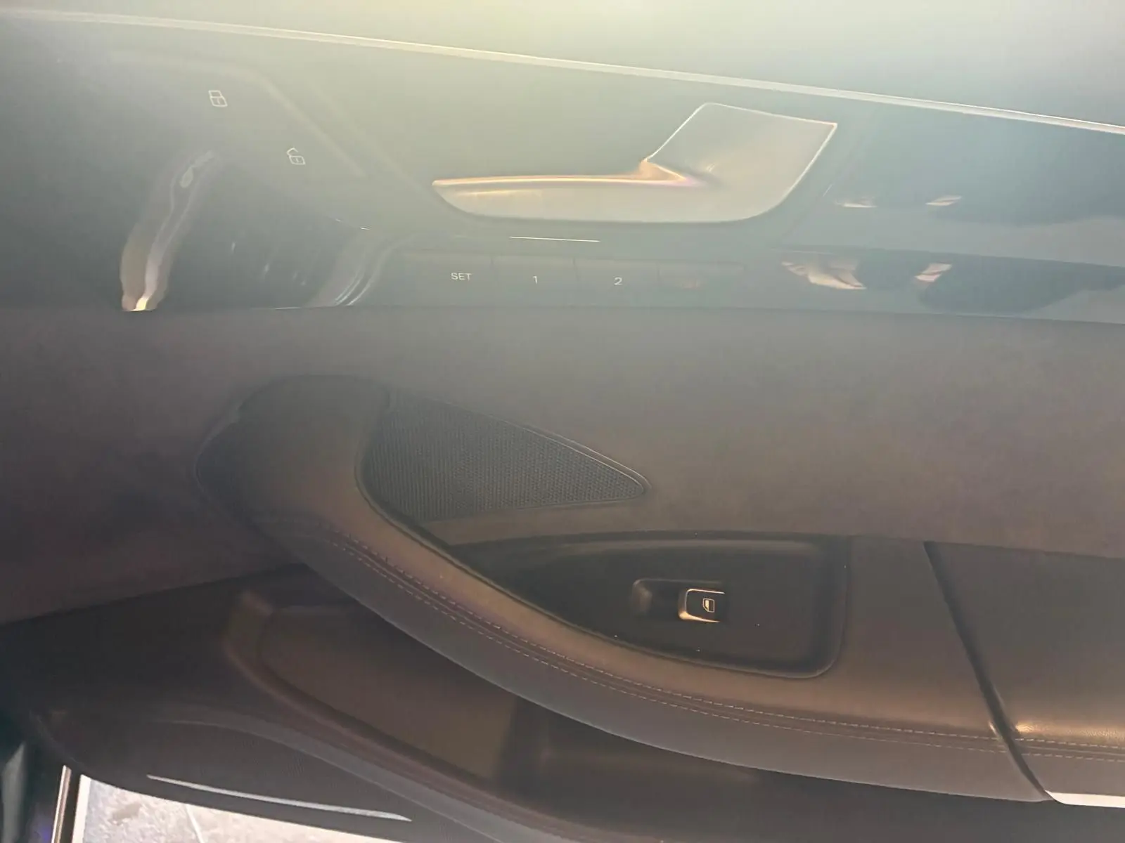 Détail de la porte intérieure côté conducteur de l'Audi A8 noire 2016, mettant en valeur la poignée et les commandes de réglage.