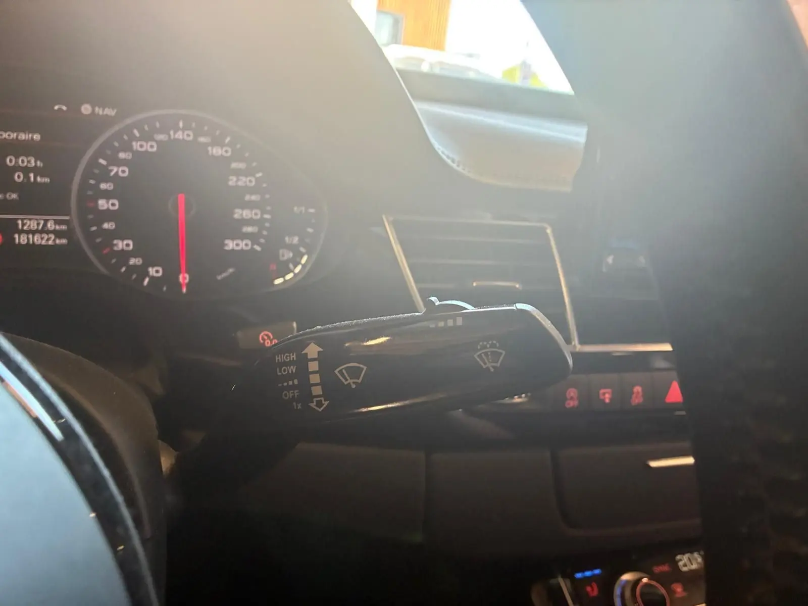 Gros plan sur la manette d'essuie-glace à gauche du volant dans l'habitacle noir de l'Audi A8 2016.