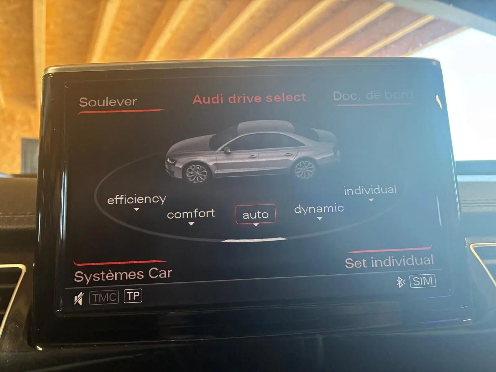 Écran central de l'Audi A8 2016 montrant le menu Audi drive select avec mode auto sélectionné, intérieur noir.