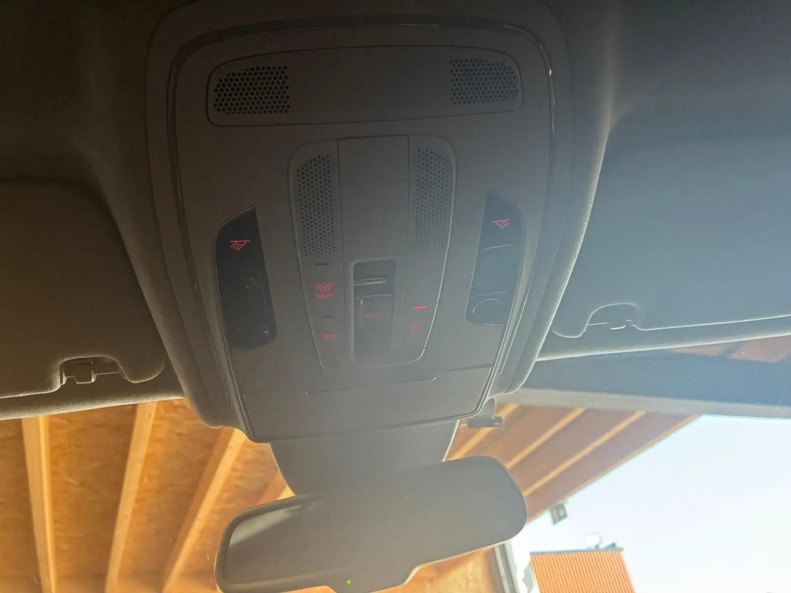 Vue intérieure du plafonnier avec commandes lumineuses et rétroviseur d’une Audi A8 noire de 2016.
