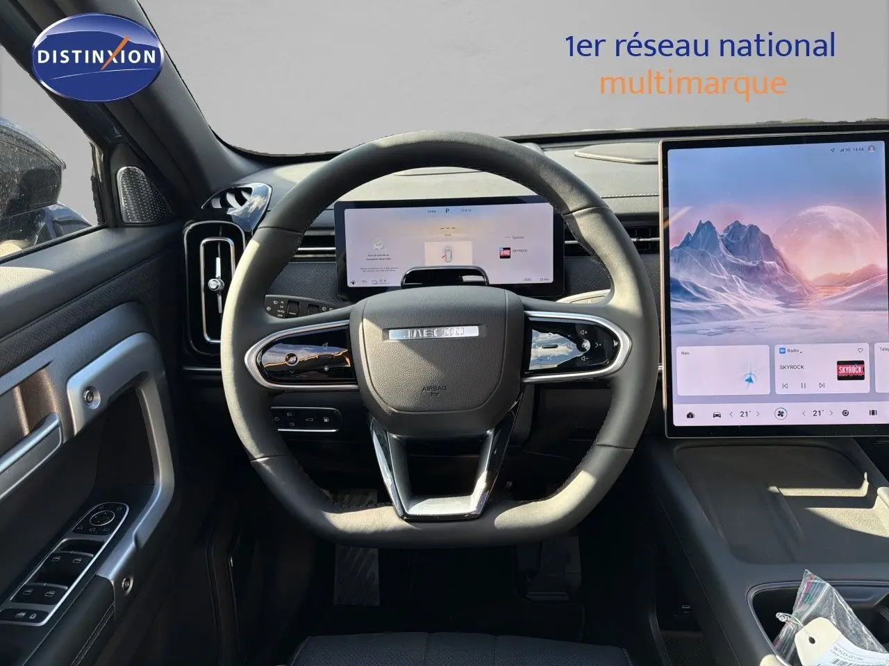 Vue intérieure centrée sur le volant JAECOO avec tableau de bord numérique et grand écran tactile vertical.