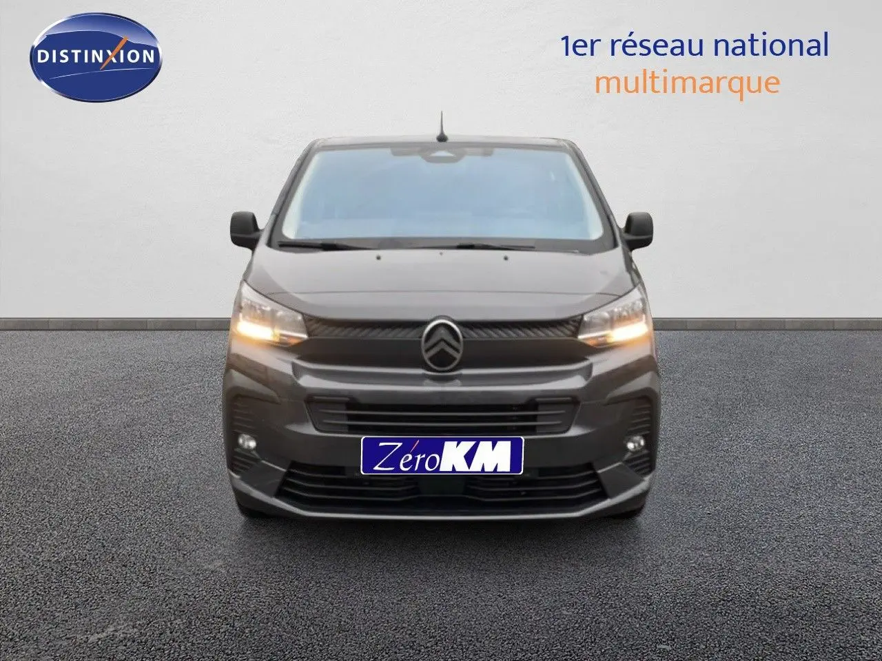 Vue avant d'un Citroën Jumpy Cabine Approfondie gris titane métal avec feux allumés sur fond neutre.