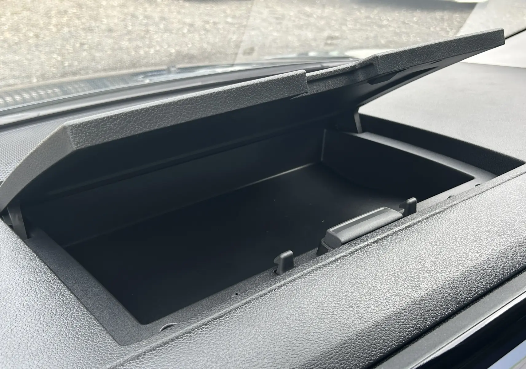 Gros plan intérieur sur le rangement ouvert du tableau de bord du Citroën Jumpy Cabine Approfondie gris titane.