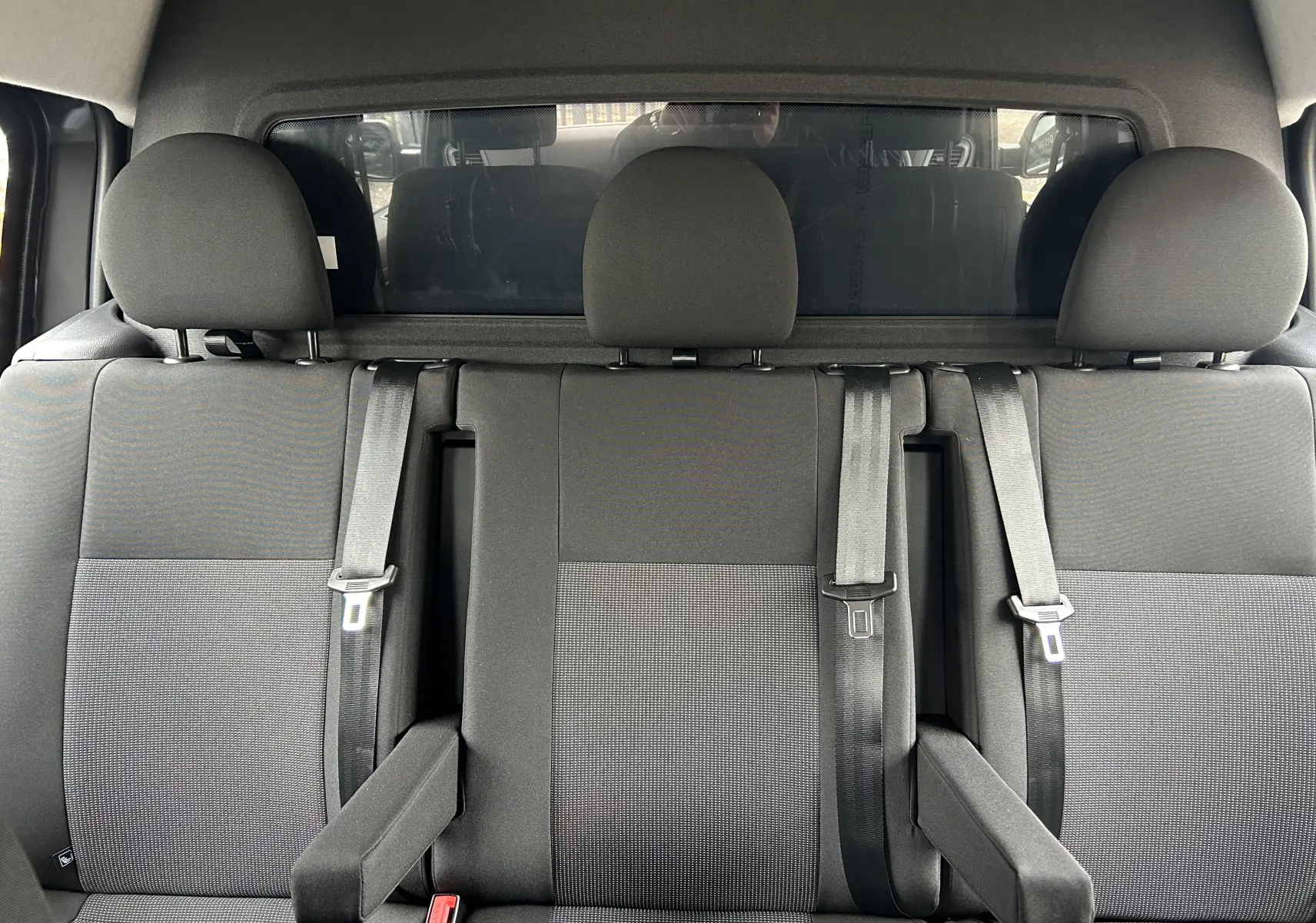 Vue intérieure montrant la banquette arrière trois places en tissu noir du Citroën Jumpy Cabine Approfondie gris titane.