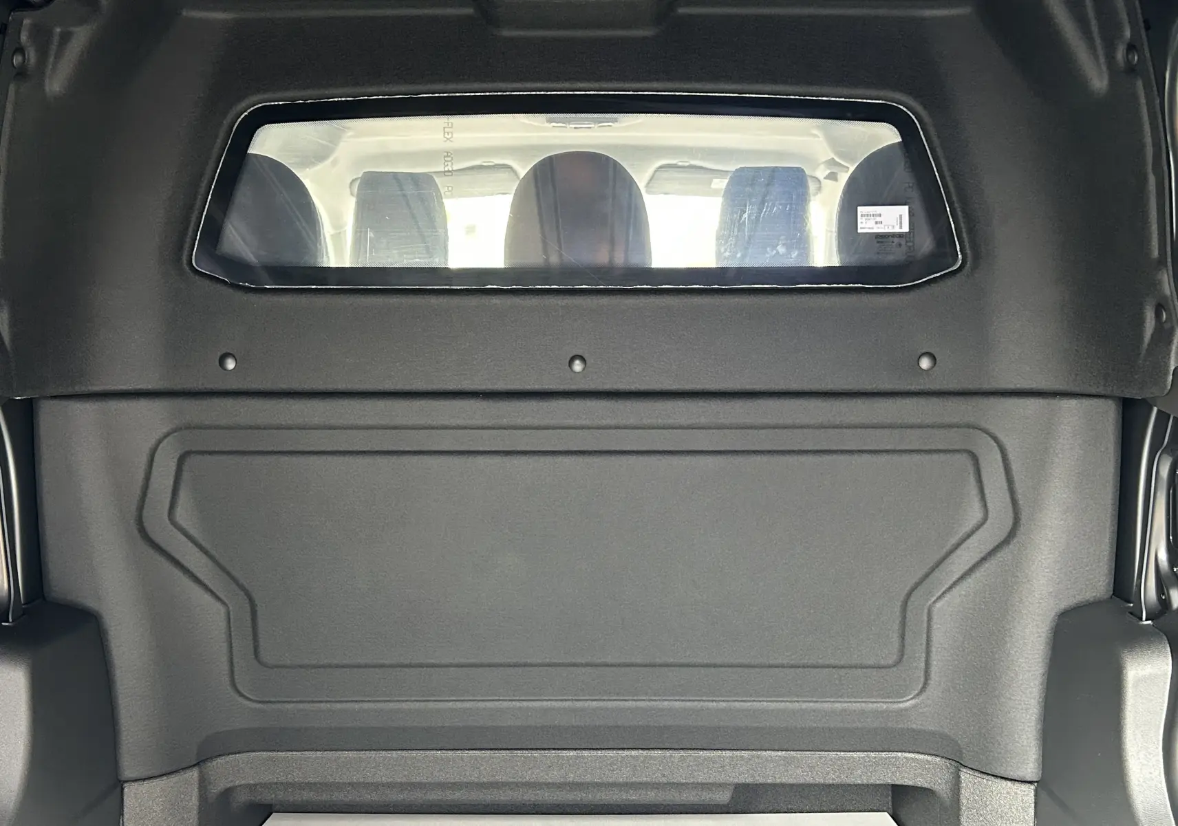 Vue intérieure arrière du Citroën Jumpy cabine approfondie gris titane, montrant la cloison séparatrice avec vitre.