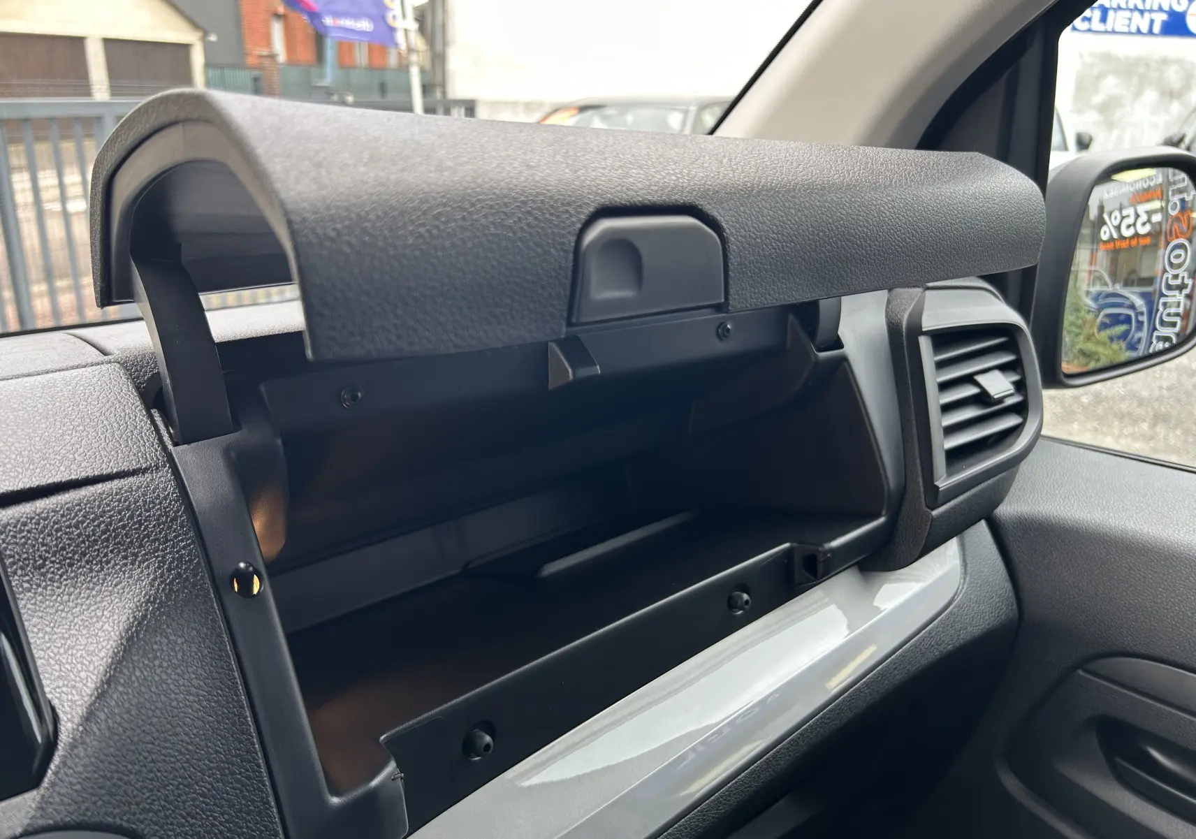 Intérieur du Citroën Jumpy cabine approfondie 2025, vue sur la boîte à gants ouverte côté passager, plastique gris et noir.
