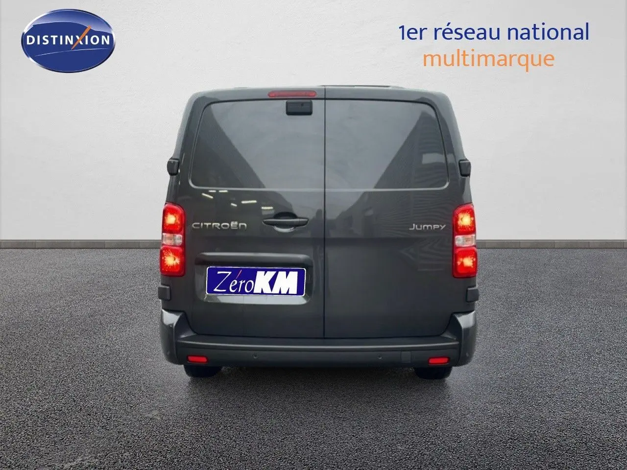 Vue arrière d’un Citroën Jumpy Cabine Approfondie gris titane métal avec feux allumés sur fond neutre.