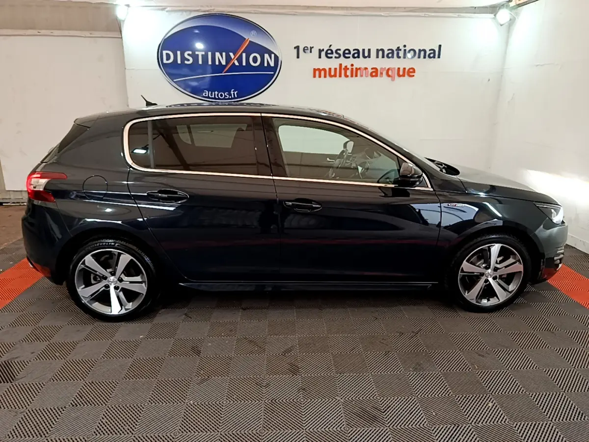 Profil droit d'une Peugeot 308 gris foncé GT Line de 2016, avec jantes alliage et vitres teintées.