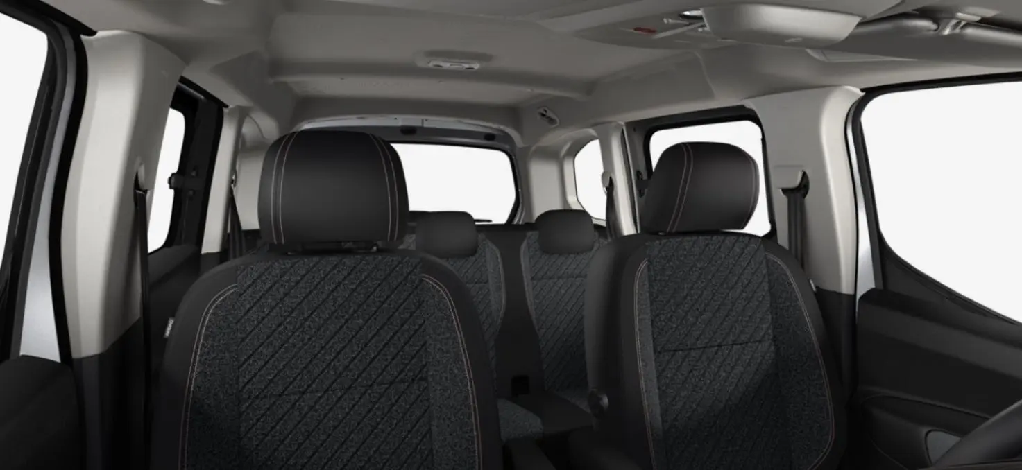 Vue intérieure du Peugeot Rifter gris acier 2026, montrant les sièges avant et arrière en tissu avec surpiqûres contrastées.